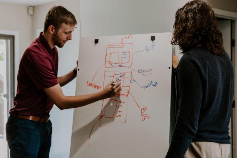 a teacher using a whiteboard to explain a subject to a student
