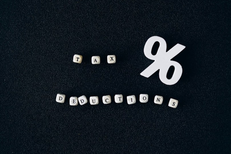 Black background with white cubes spelling out 'Tax deductions', and a percentage sign