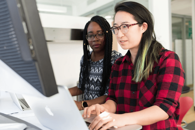 two people looking over a computer
